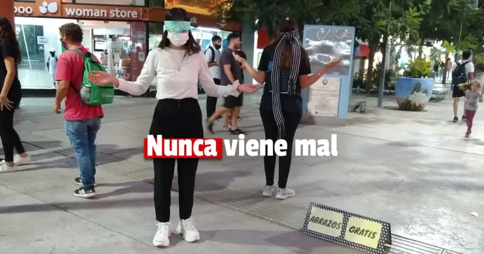 Muchos niños aceptan los "abrazos gratis" de dos jóvenes en pleno microcentro 